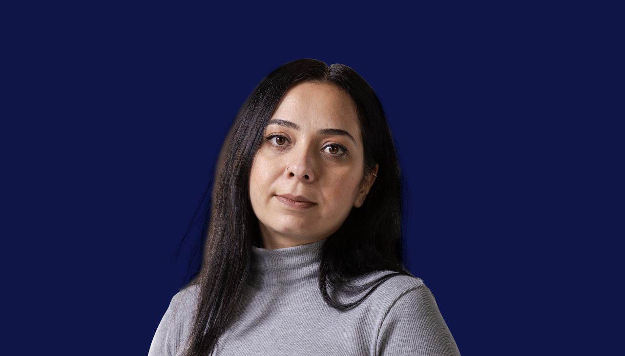 woman with long black hair wearing a grey turtleneck sweater